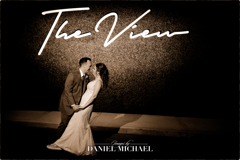 Couple looking at each other in front of "The View" sign wall